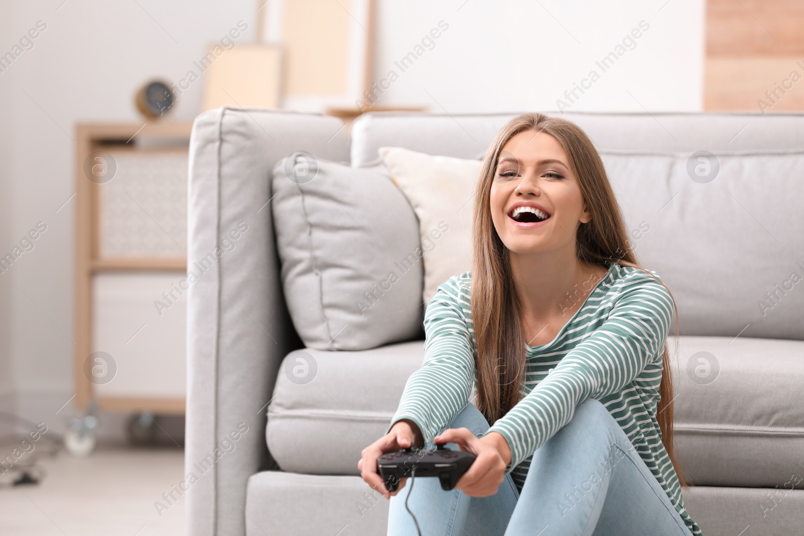 Photo of Emotional young woman playing video games at home