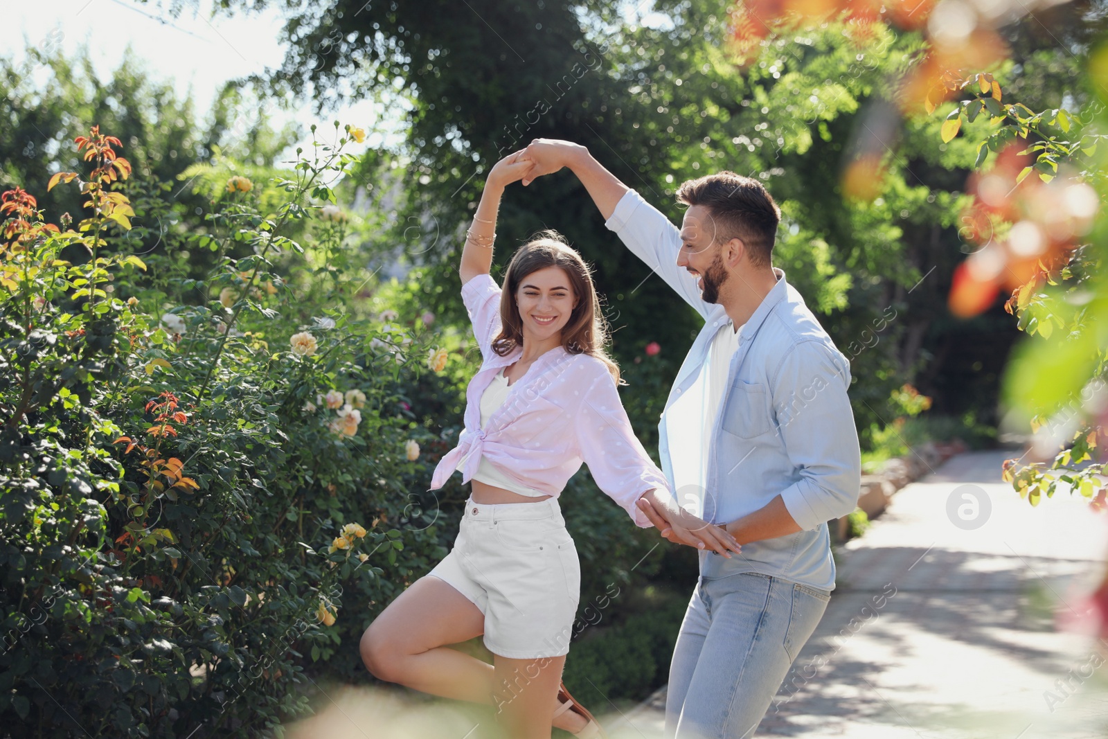 Photo of Lovely young couple dancing together in park on sunny day