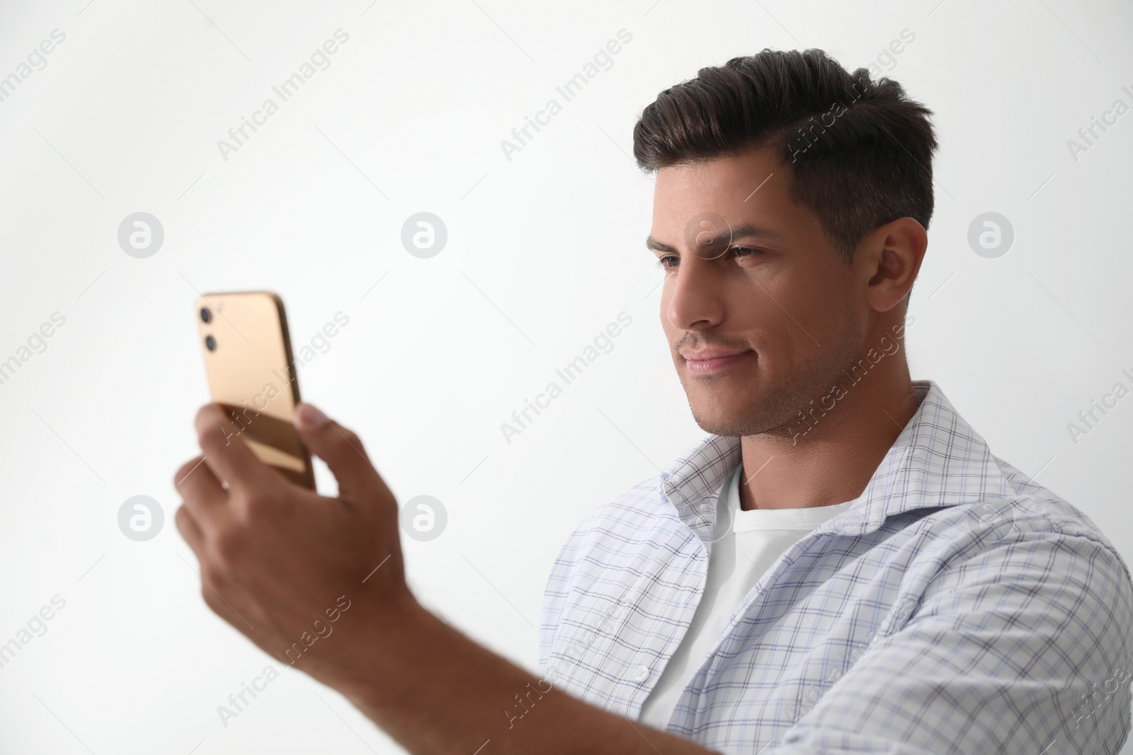 Photo of Man unlocking smartphone with facial scanner on white background. Biometric verification