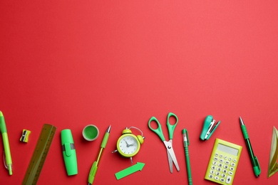 Photo of Different bright school stationery on red background, flat lay. Space for text