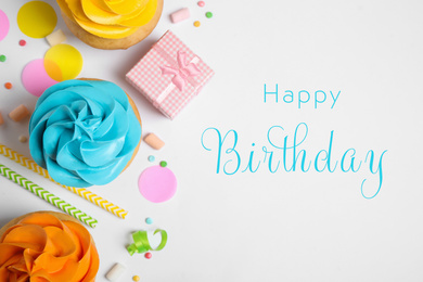 Image of Flat lay composition with delicious cupcakes and text Happy Birthday on white background