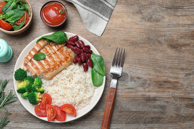 Photo of Tasty rice with beans served on wooden table, flat lay. Space for text