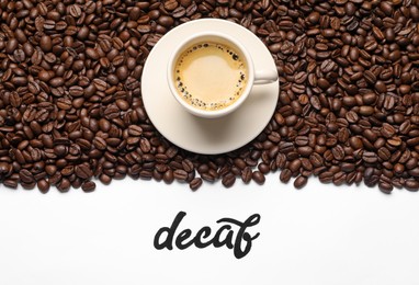 Word Decaf, cup of coffee and beans on white background, flat lay