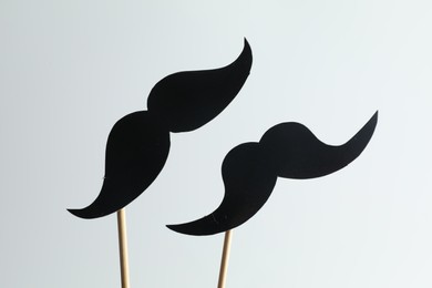 Photo of Fake paper mustaches party prop on light background