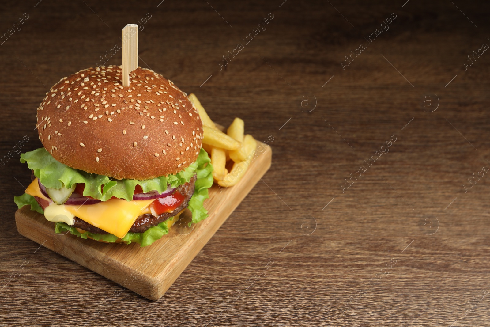 Photo of Delicious burger with beef patty and french fries on wooden table, space for text