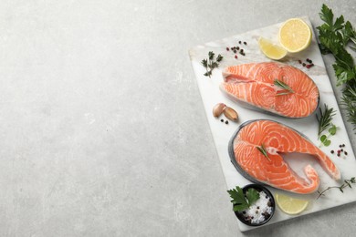 Photo of Fresh salmon and ingredients for marinade on light grey table, top view. Space for text