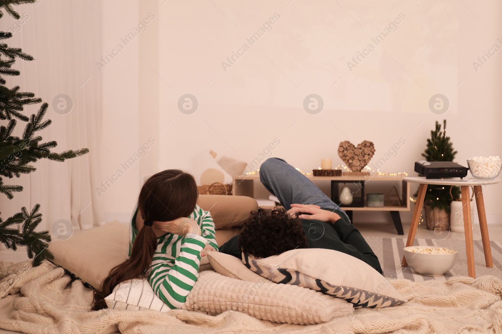 Photo of Couple watching movie via video projector at home