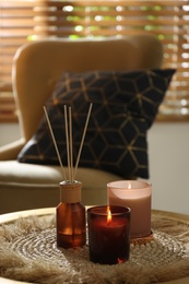 Photo of Air reed freshener and candles on table in room