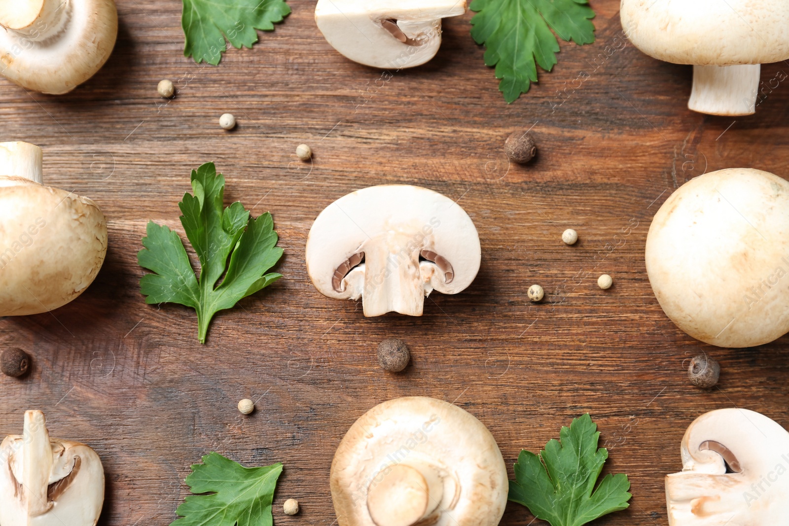 Photo of Flat lay composition with fresh champignon mushrooms on wooden background