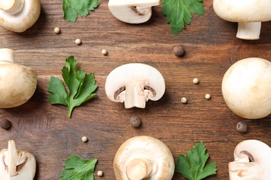 Flat lay composition with fresh champignon mushrooms on wooden background