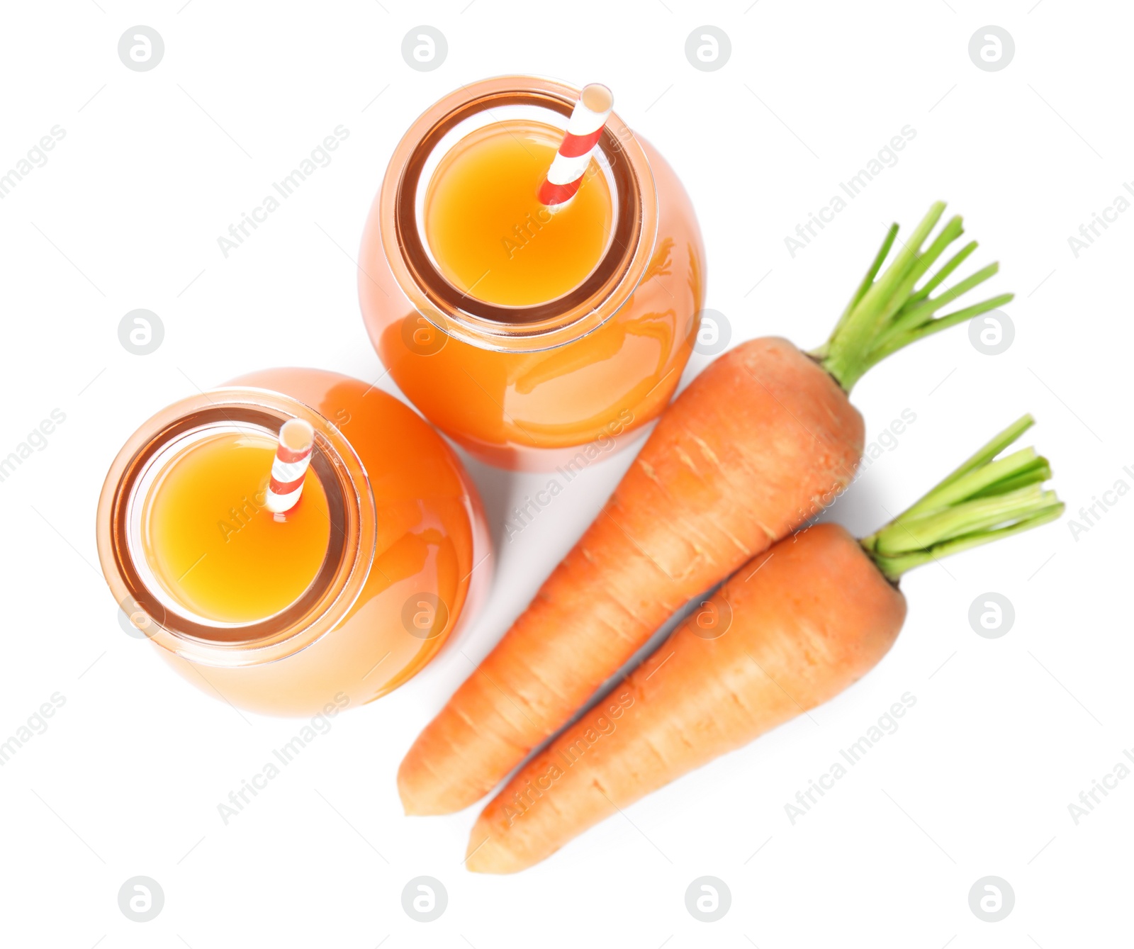 Photo of Freshly made carrot juice in glass bottles on white background, top view