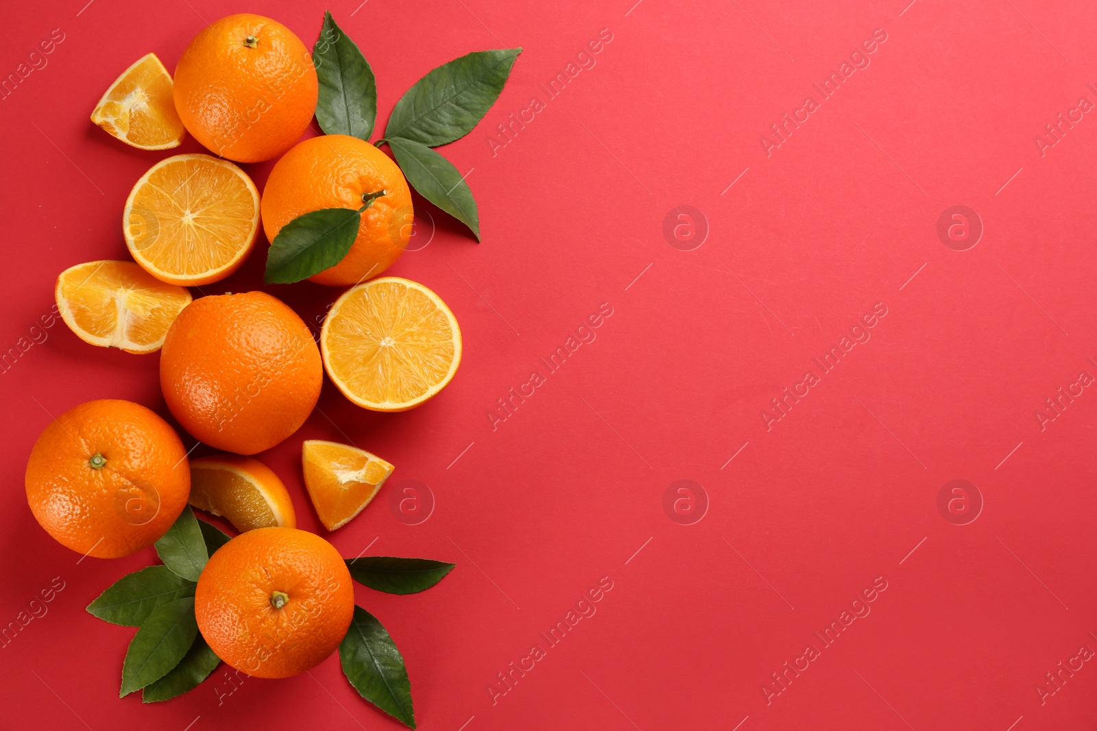 Photo of Delicious oranges on red background, flat lay. Space for text