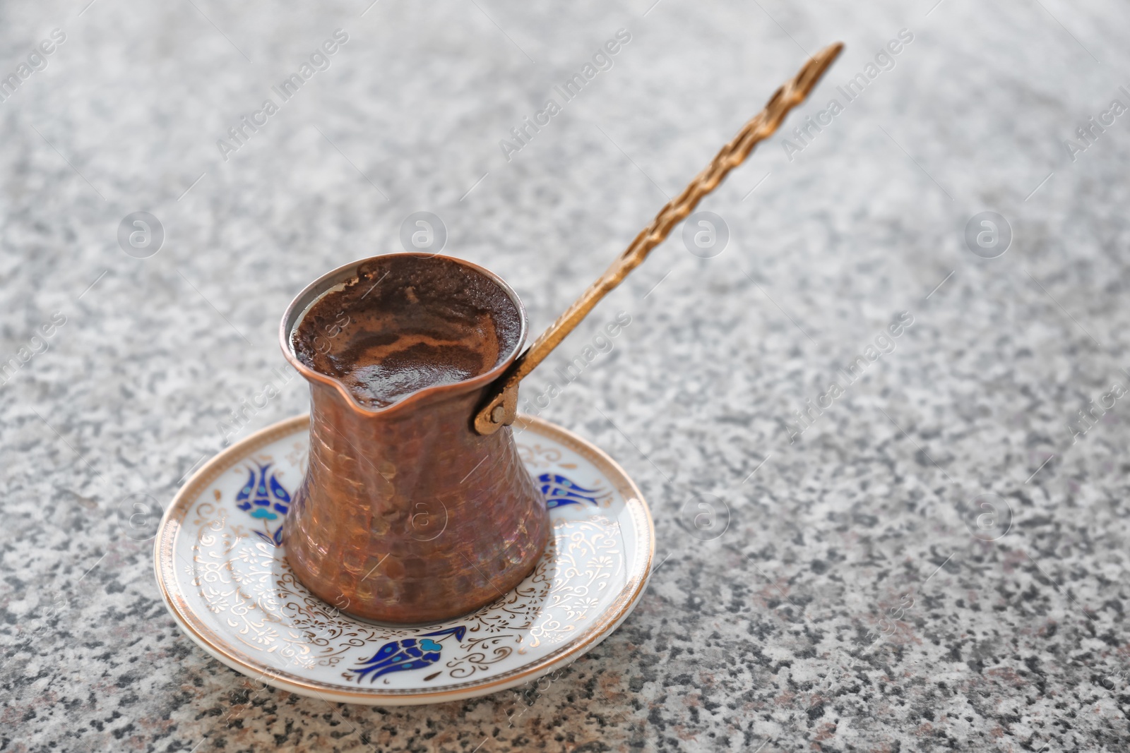 Photo of Jezve with aromatic coffee on table