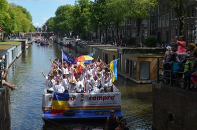 AMSTERDAM, NETHERLANDS - AUGUST 06, 2022: Many people in boats at LGBT pride parade on river