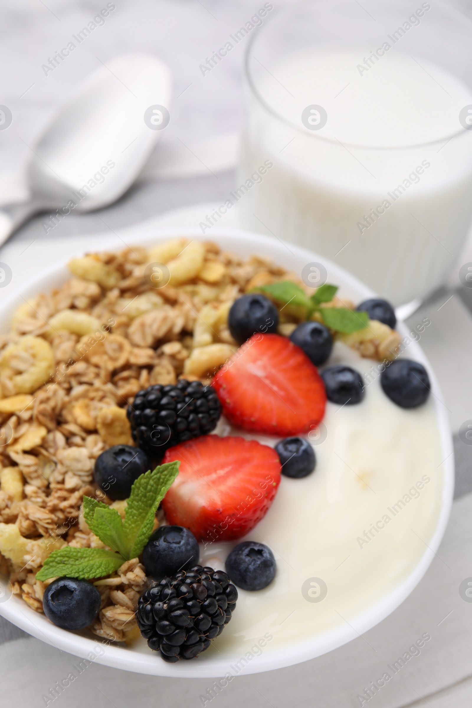 Photo of Tasty oatmeal, yogurt and fresh berries in bowl on table, closeup. Healthy breakfast