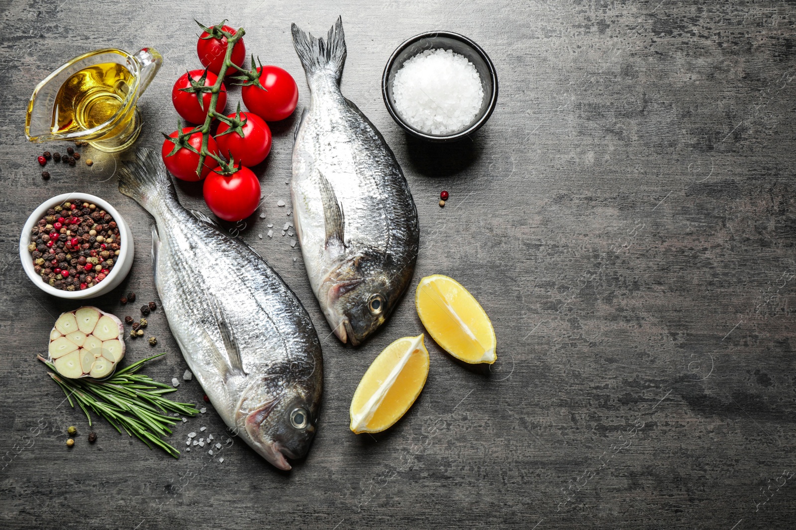 Photo of Flat lay composition with raw dorada fish on grey table