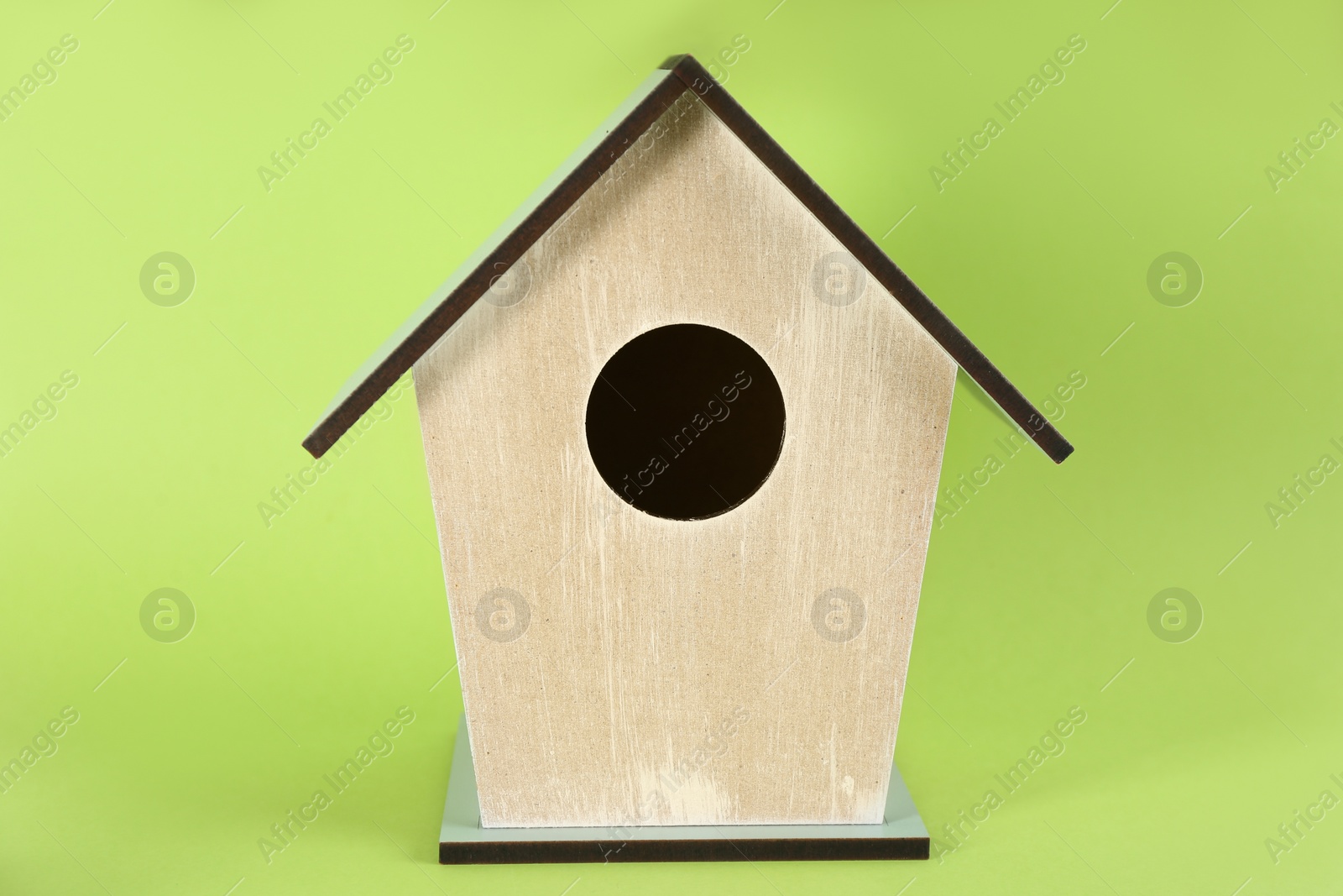 Photo of Beautiful wooden bird house on green background