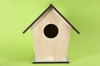 Beautiful wooden bird house on green background