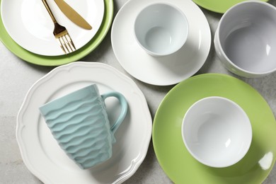 Photo of Beautiful ceramic dishware, cup and cutlery on light grey table, flat lay