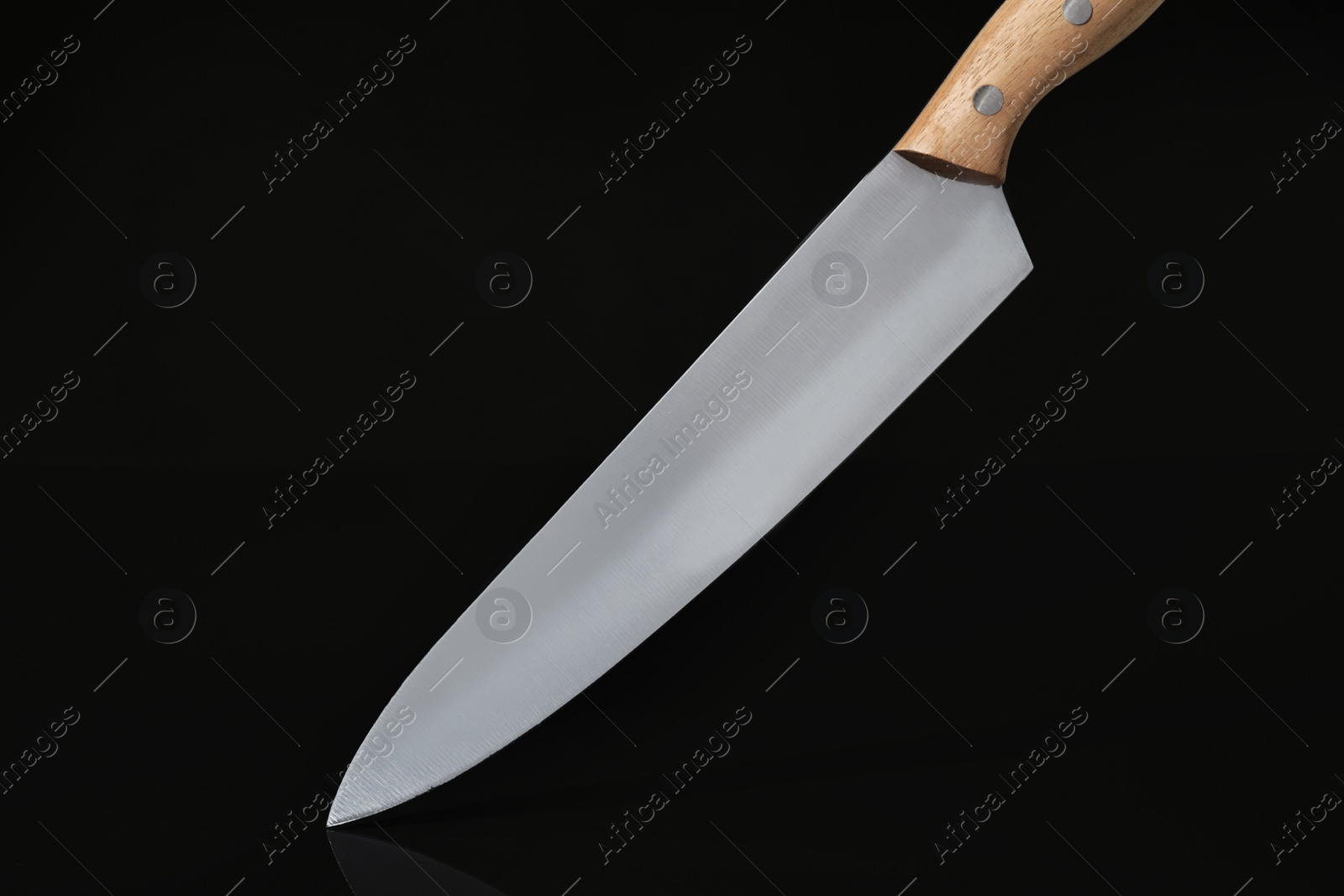 Photo of Sharp knife with wooden handle on black background