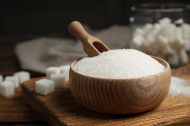 Granulated sugar in bowl on wooden table