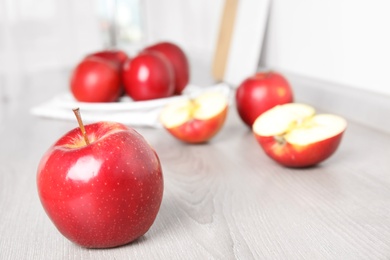 Photo of Ripe juicy red apples on white wooden table indoors