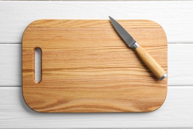 Photo of One sharp knife and board on white wooden table, top view