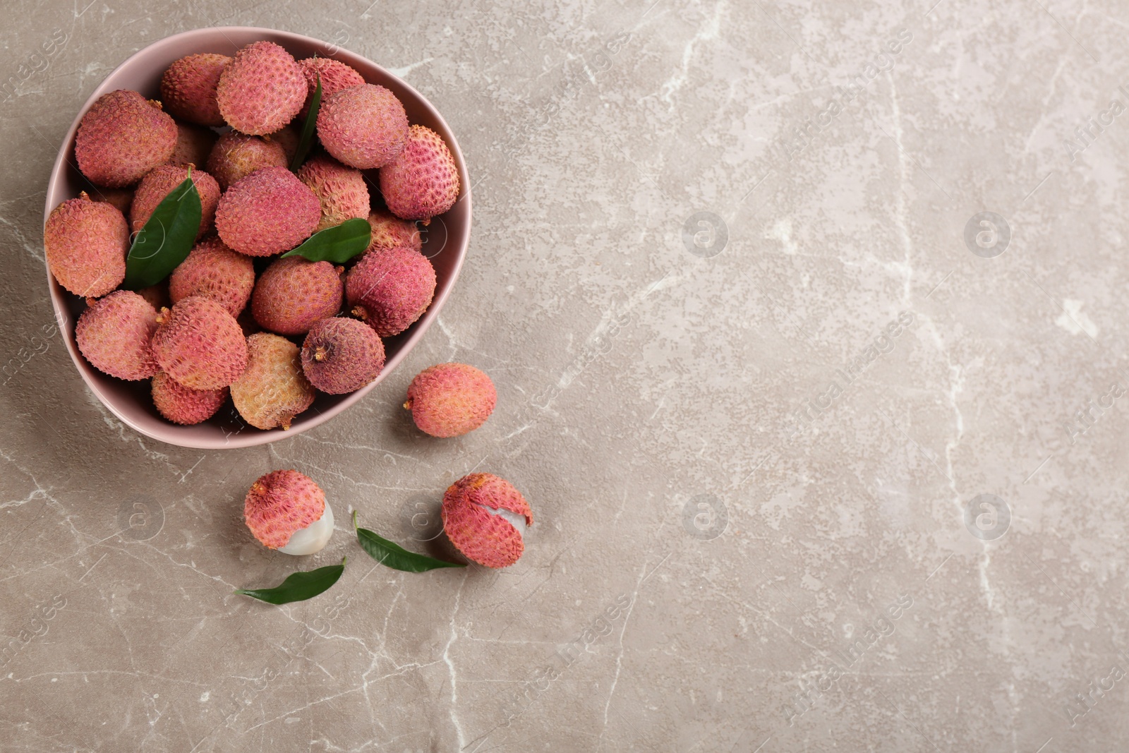 Photo of Fresh ripe lychee fruits on grey table, flat lay. Space for text