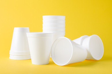Photo of Many white styrofoam cups on yellow background
