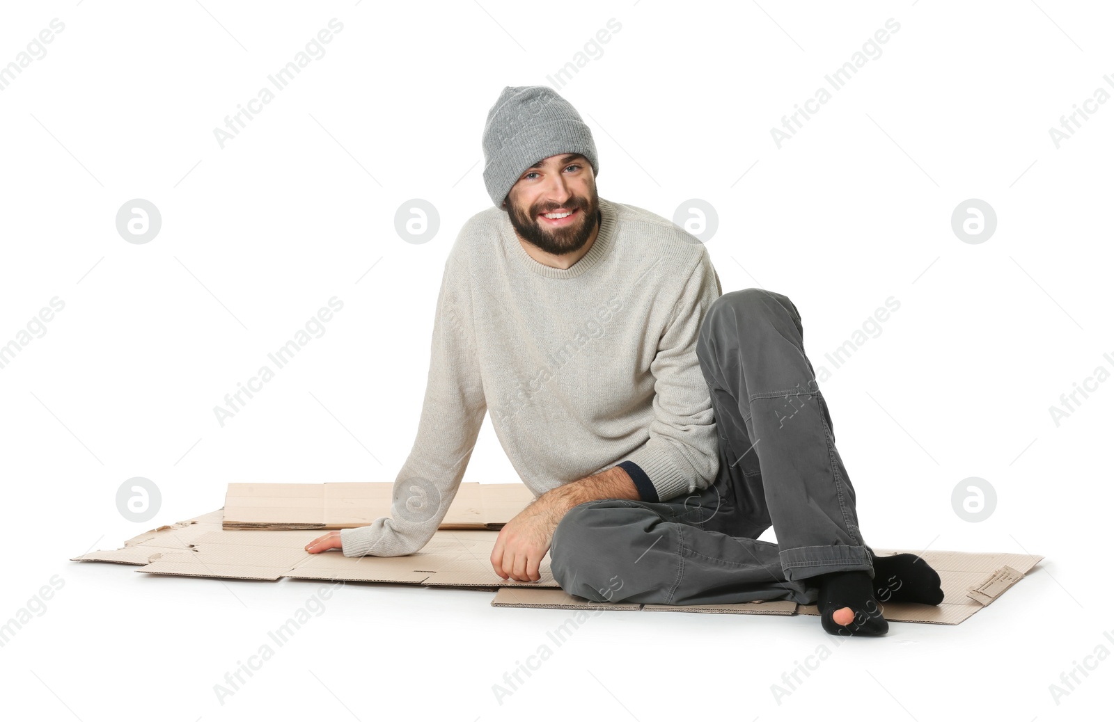 Photo of Poor homeless man sitting on cardboard, white background