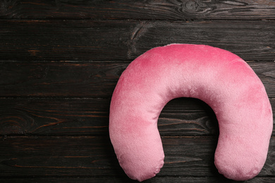 Image of Pink travel pillow on wooden background, top view. Space for text