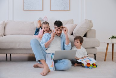 Photo of Overwhelmed man combining parenting and work at home