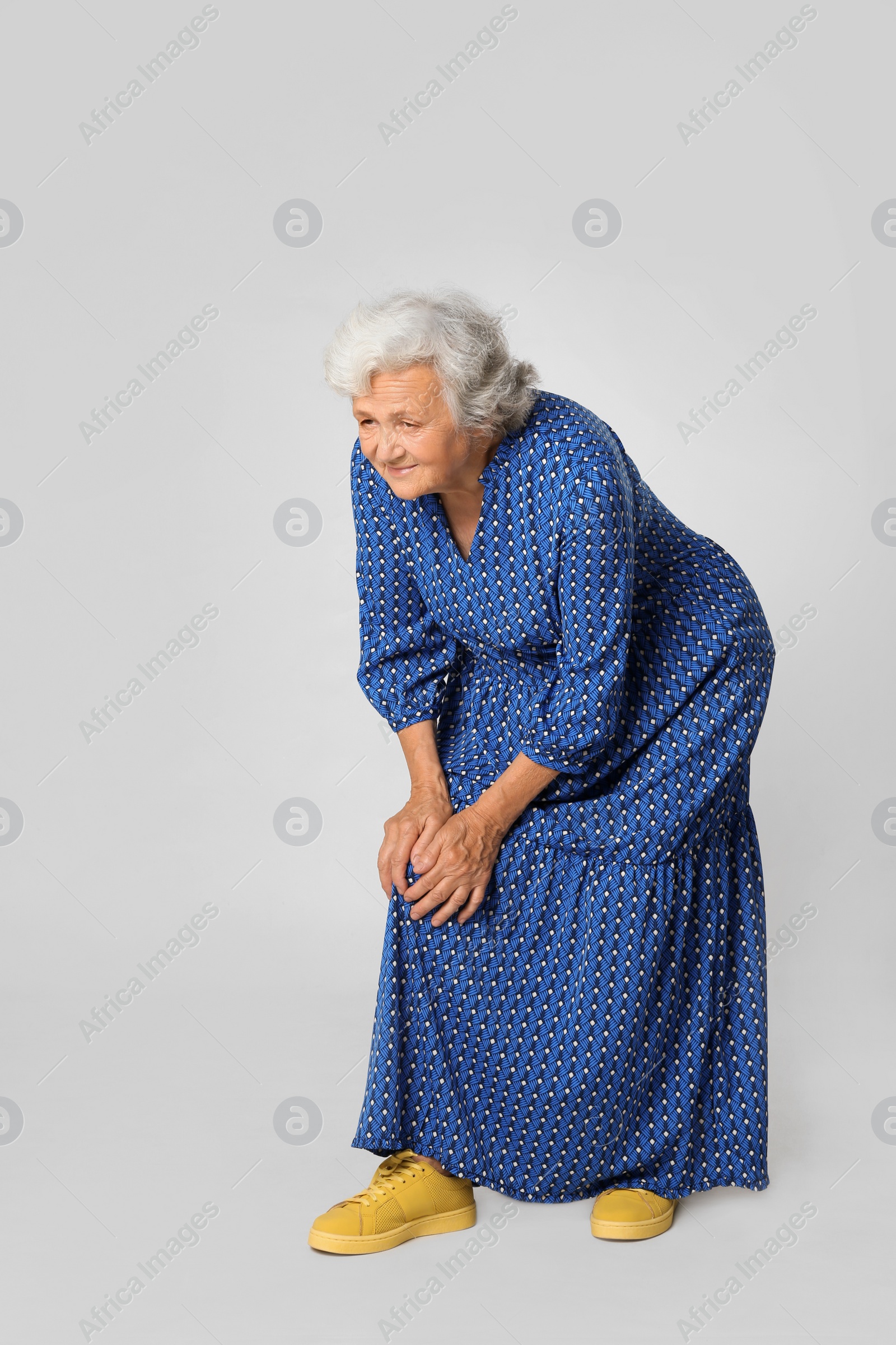 Photo of Full length portrait of senior woman having knee problems on grey background