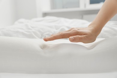 Photo of Woman with orthopedic memory foam pillow on bed, closeup. Space for text