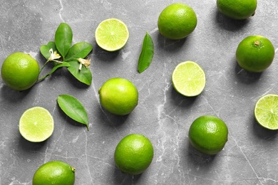 Flat lay composition with fresh ripe limes on gray background, top view