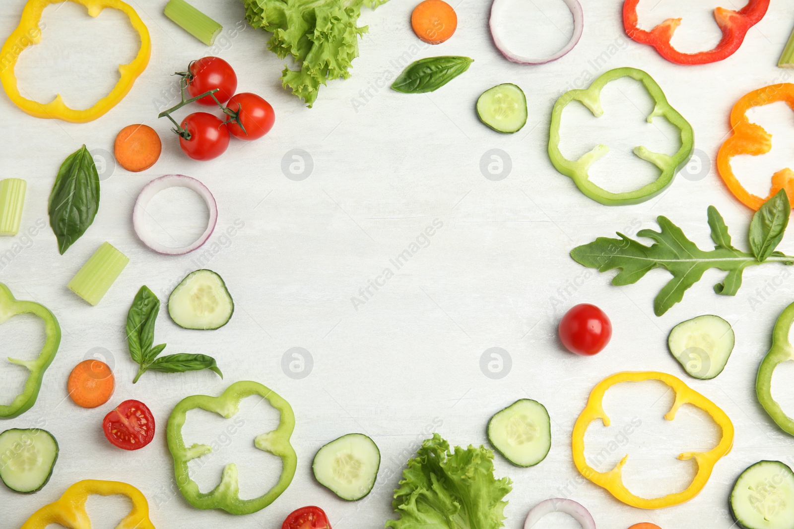 Photo of Frame made with fresh salad ingredients on white wooden table, flat lay. Space for text