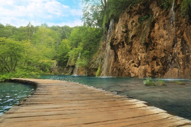 Photo of Wooden bridge over river and beautiful waterfall