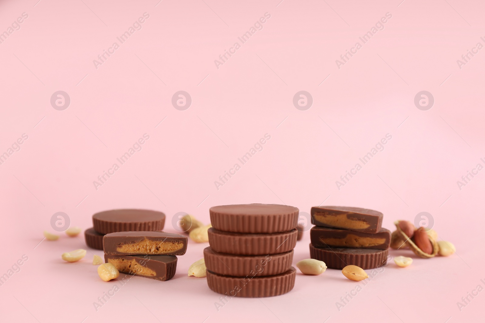 Photo of Sweet peanut butter cups on pink background