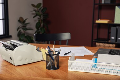 Banknote counter and office supplies on wooden table indoors