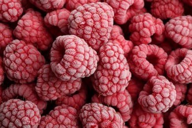 Tasty frozen raspberries as background, top view