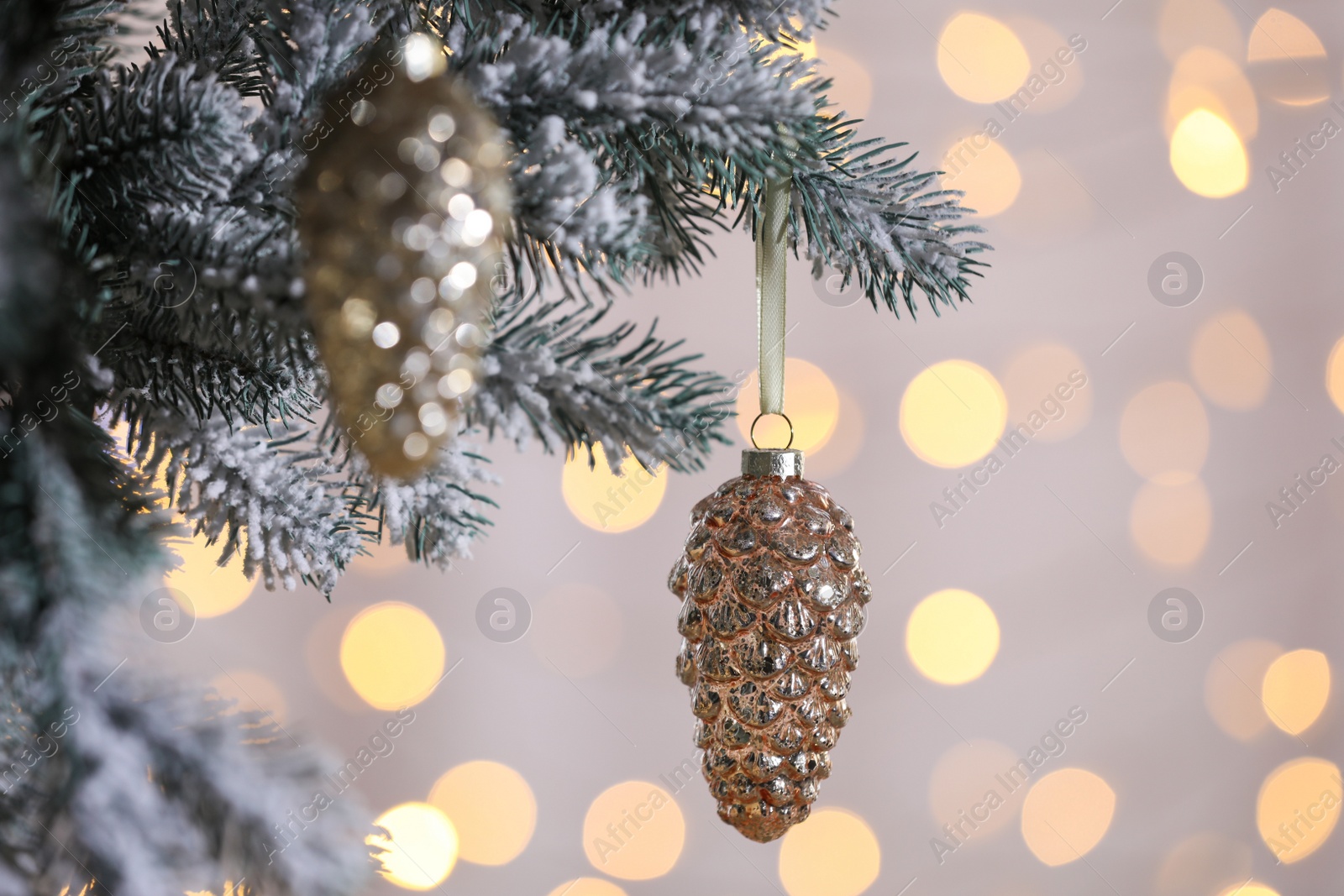 Photo of Christmas tree decorated with holiday baubles against blurred lights, closeup