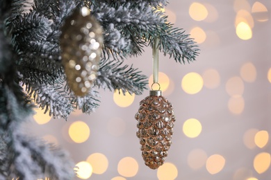 Christmas tree decorated with holiday baubles against blurred lights, closeup