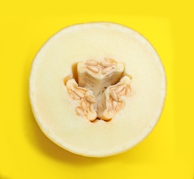 Half of ripe tasty melon on yellow background, top view