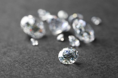 Beautiful shiny diamond on gray table, closeup. Space for text