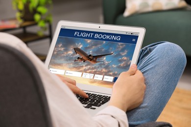 Image of Man using laptop to book flight at home, closeup