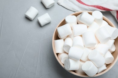 Photo of Delicious puffy marshmallows on grey table, flat lay. Space for text