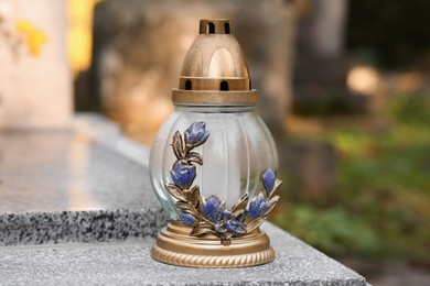 Grave lantern on granite surface in cemetery