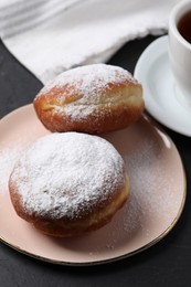 Photo of Delicious sweet buns and cup of drink on dark gray table