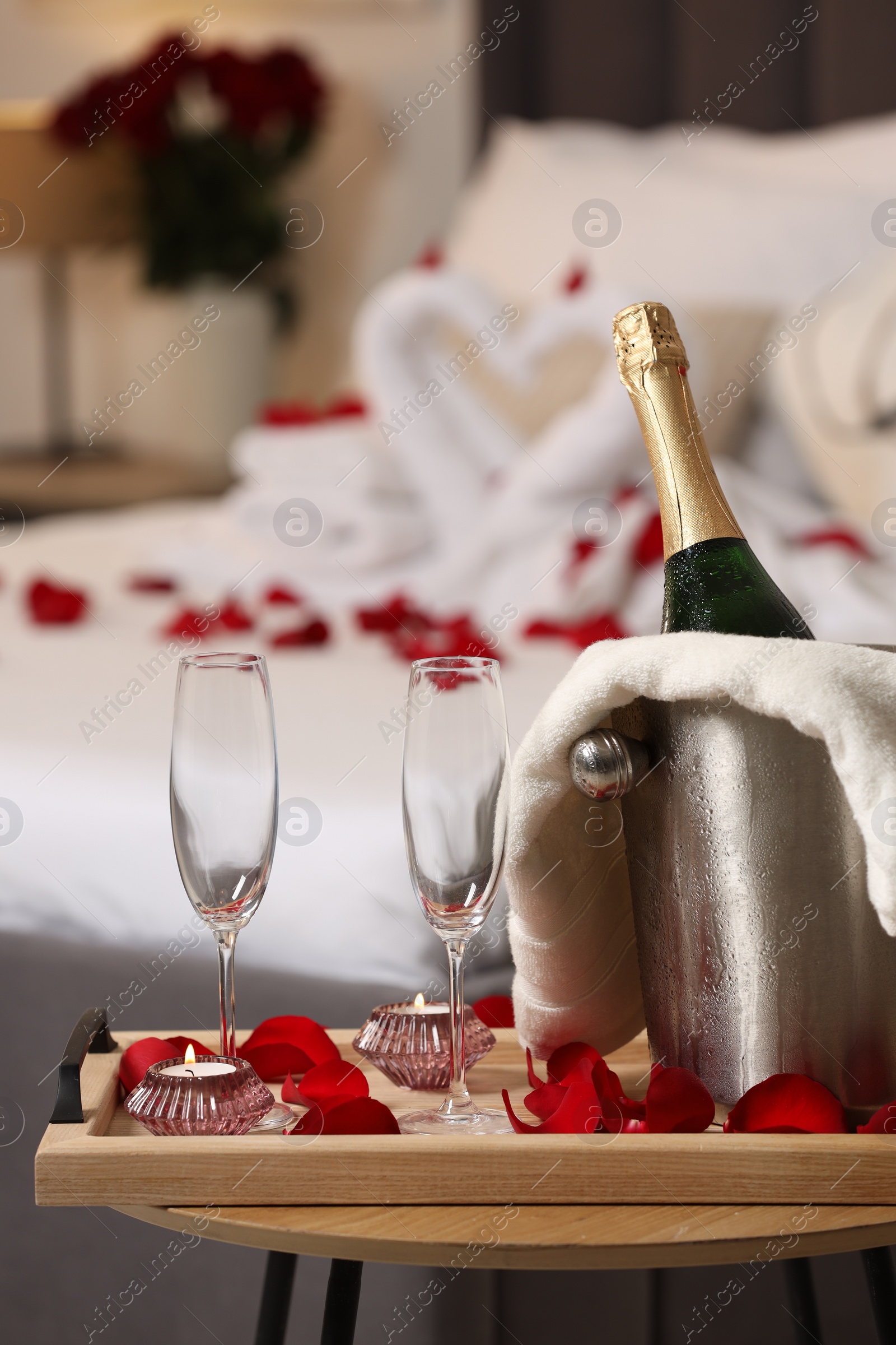 Photo of Honeymoon. Sparkling wine and glasses on wooden table in room