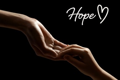 Concept of hope. Woman with child on black background, closeup of hands